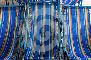 Blue canvas beds under beach umbrellas await visitors at Thailand