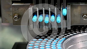 Blue capsule medicine pill production line, Industrial pharmaceutical concept.