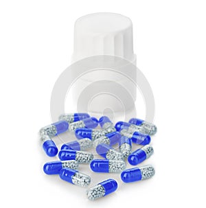 Blue capsules, pills poured out of a white bottle close-up on a white background.