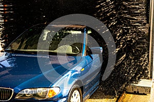 blue car on an automatic washing bench