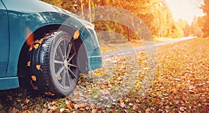 Blue car on the autumnal asphalt road in countryside