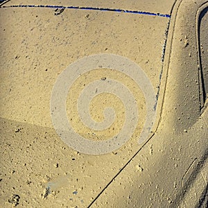 Blue car crusted with dry mud