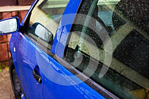 Blue car door handle with rain drops