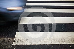 Blue car in motion and pedestrian crossing