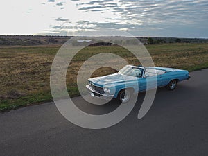 Blue car parked on the road against the background of the sunny sky. Retrocar