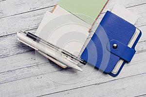 blue card holder letterhead notepads pen check wooden background finance