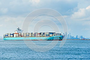Blue cargo container ship anchored in harbor