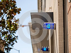 Blue caution safety lights affixed to building outside and positioned high