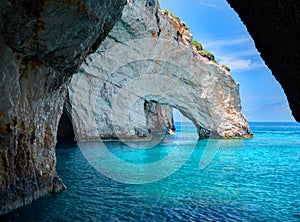 Blue caves rock arces arches of Blue caves from sightseeing boat with tourists in blue water of Ionian Sea inside cave, Island Zak