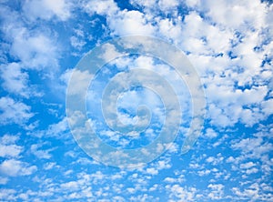 Blue celestial background with white fleecy clouds