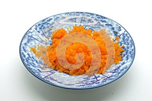 Blue ceramic bowl, bone china, porcelain of orange tobiko, shrimp egg, flying fish caviar, roe