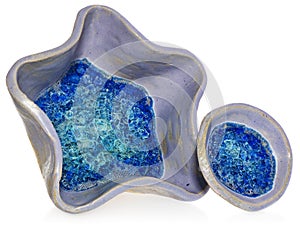 Blue, ceramic, handmade bowls in the shape of a star and round. At the bottom of vessel broken glass with bubbles of air.