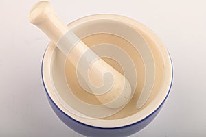 Blue ceramic spice mortar with pestle on white background. Close up