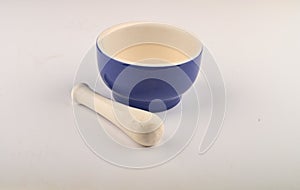 Blue ceramic spice mortar with pestle on white background. Close up