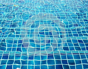 Blue ceramic wall tiles and details of surface on swimming pool