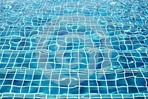 Blue ceramic wall tiles and details of surface on swimming pool