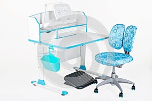 Blue chair, school desk, blue basket, desk lamp and black support under legs