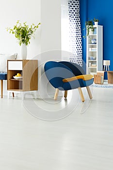 Blue chair in white room