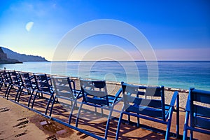 Blue chairs along the Promenade des Anglais on the Mediterranean Sea at Nice, France