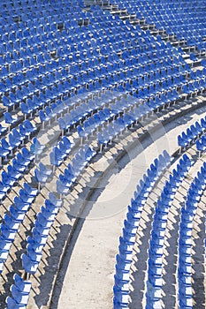 Blue chairs in an empty amphitheater hall