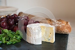 Blue cheese on a plate with grapes.