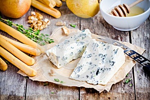 Blue cheese slices with breadsticks, nuts and honey