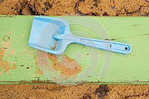 Blue children shovel toy on white sand, plastic play for game. Mound of sand in kindergarden.