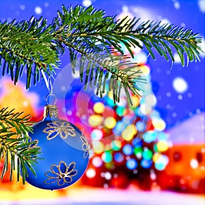 Blue Christmas ball in front of Christmas tree