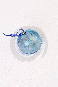Blue christmas ball in snow.