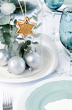 Blue christmas dinner table setting with glass dome centerpiece