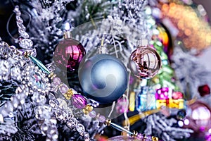 Blue Christmas glass bauble and pink ball decoration hanging on a snowy tree bg