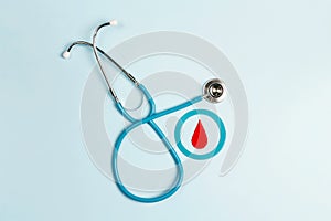 Blue circle with a drop of blood as a symbol of diabetes with stethoscope on a blue background