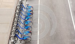 Blue city bikes parked on the street, view from above