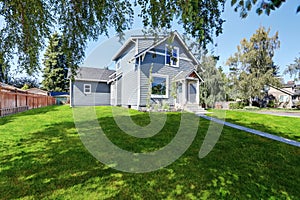 Blue clapboard siding house with grass filled front yard.