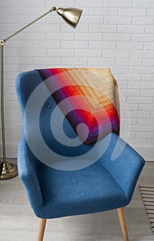 Blue classical style armchair sofa couch in living room with desk lamp on brick wall background