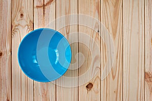 Blue clean plate on wooden background with copy space.