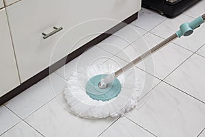 Blue cleaning mop on white ceramic tile floor
