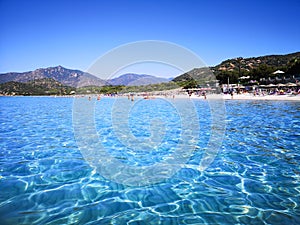 The blue clear water and white sand of a beach in Sardinia