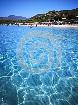 The blue clear water and white sand of a beach in Sardinia