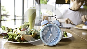 Blue clock and breakfast time, alarm clock intermittent fasting as a healthy and balanced breakfast