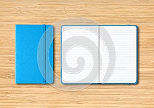 Blue closed and open lined notebooks on wooden background