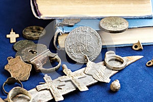 On a blue cloth background, ancient 19th-century coins, a rusty knife and personal items of people who lived long ago