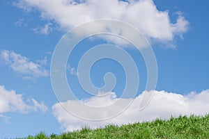 Blue cloudy sky and green grass background copy space