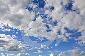 A blue cloudy sky with many small clouds blocking the su photo