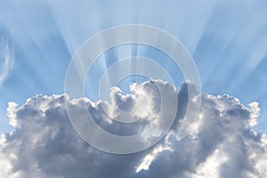 Blue cloudy sky, sun rays break through the clouds, background with sun flare, place for text