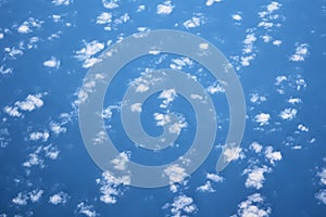 Blue cloudy sky, view from the airplane window. Aerial view of cloudscape, abstract background