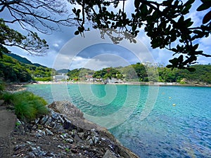 Blue coastline and people on the beach in the background of the Izu Peninsula in Honshu, Japan