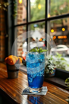 Blue cocktail on the bar counter. A photo of blue cocktail with ice and mint in it