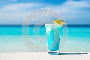 blue cocktail on the white sand of a paradisiacal beach with the sea in the background. Copy space. Ai generative