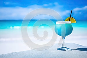 blue cocktail on the white sand of a paradisiacal beach with the sea in the background. Copy space. Ai generative